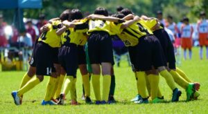 円陣を組むサッカーチームの子どもたち