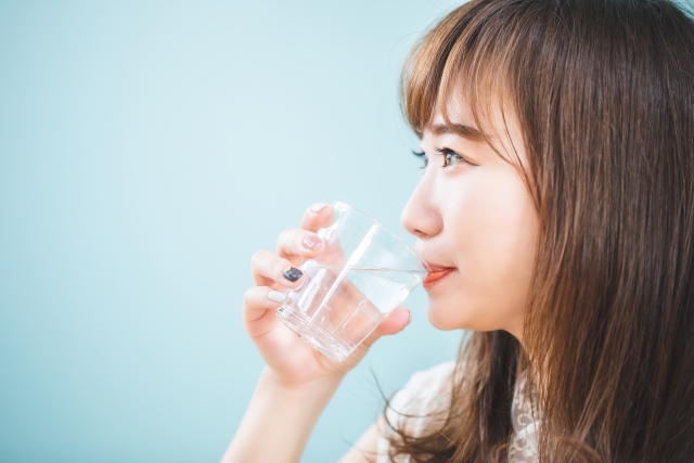 コップの水を飲む女性